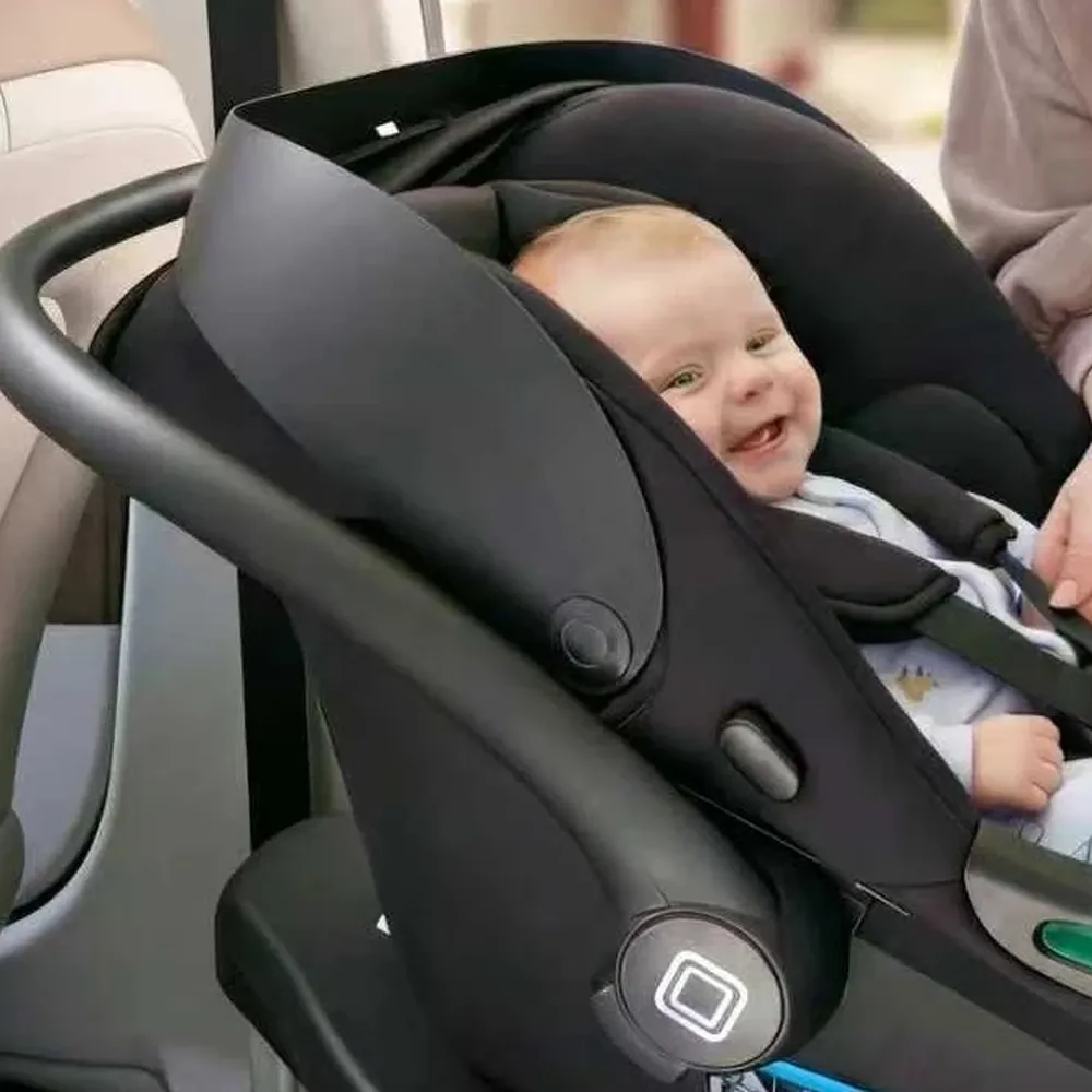 Baby wird in der MOON Babyschale LOLA im Auto angeschnallt