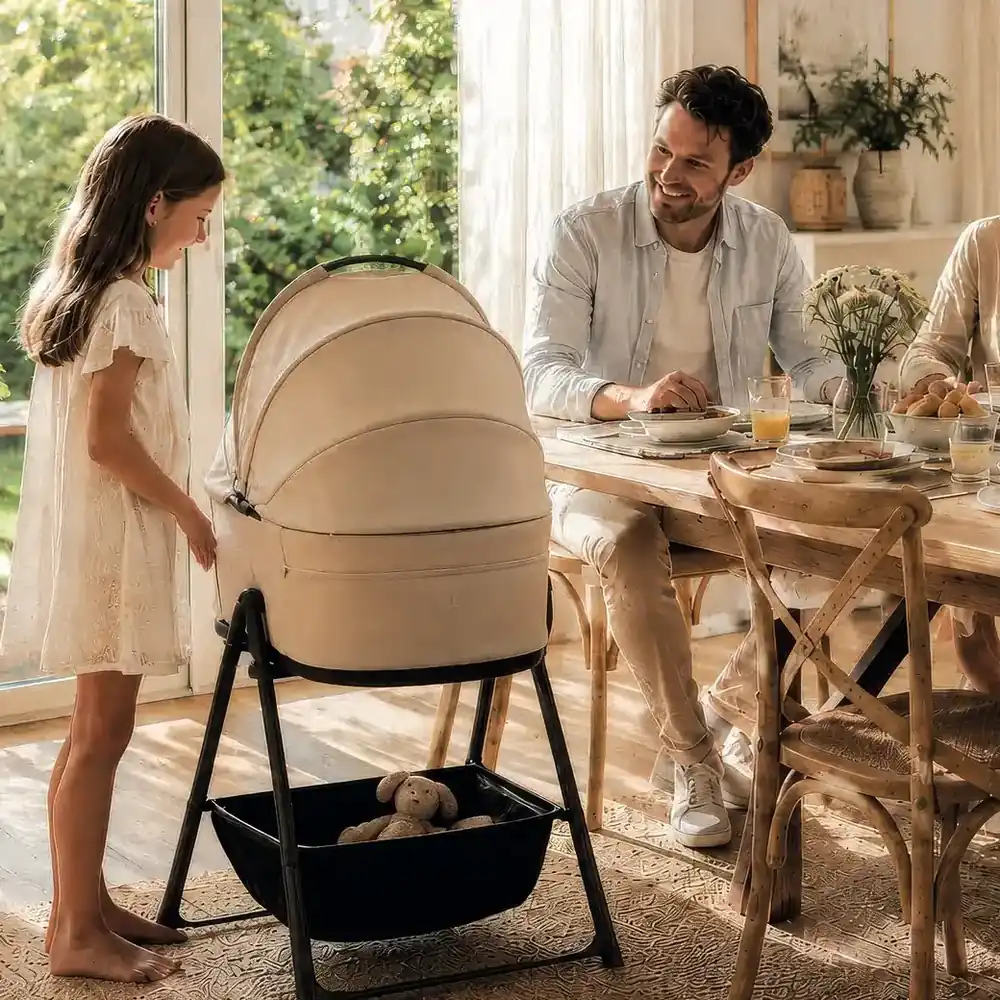 Familie am Esstisch, daneben eine MOON Babywanne auf dem Wannenständer